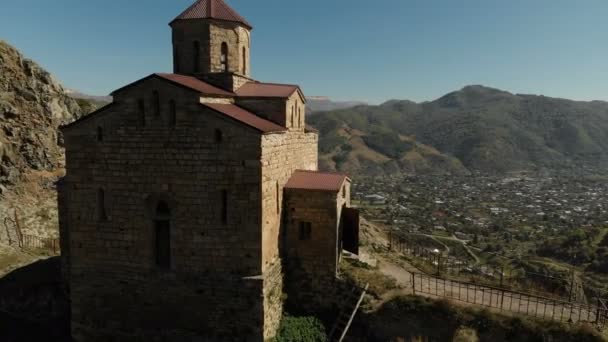 4K UHD Vista aérea de un monasterio de montaña de pie sobre un acantilado. Antiguo templo cristiano del siglo X situado en Karachay-Cherkessia. Rusia. Cáucaso Norte — Vídeos de Stock