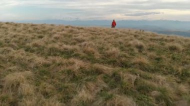 Sakallı hippi erkek bir uzaktan kumandadan bir dron ile hava bir görünümünü günbatımında yayla yakınındaki bir uçurum kenarı boyunca yol gösterir. Cliff üzerinde biri