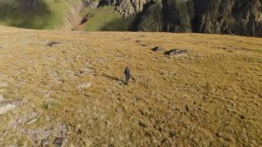 Havadan görünümü arka planda dağlar ve kayalar onun kamera ile dağlarda bir plato üzerinde yürüyen bir kız fotoğrafçı. Şu anki iş doğa 4k