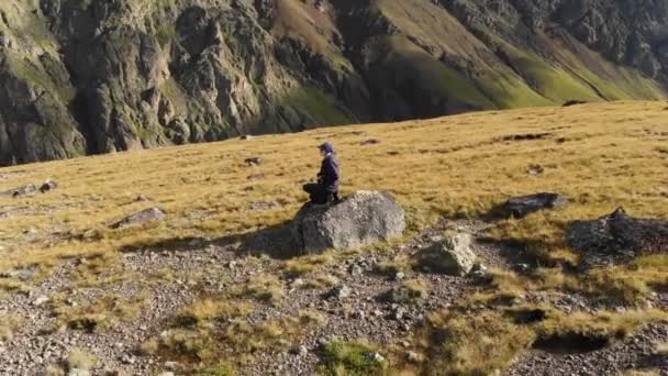 바위와 산의 배경에 그의 카메라와 함께 산에서 고원 걷는 여자 사진 작가의 공중 전망. 실제로 4 k 취미 — 비디오