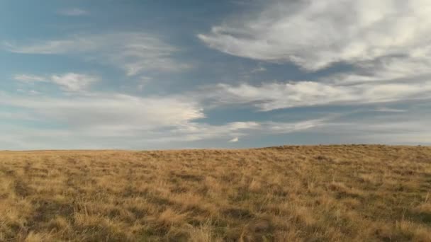 Antenne: Flug über eine hohe Felswand mit Blick auf den Pass in Russland im Nordkaukasus. Luftaufnahmen der Straße in der untergehenden Sonne. Flug neben dem Felsen — Stockvideo