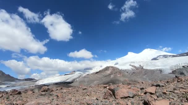 移動で空の雪をかぶった山に眠っているエルブラス山火山のふもとの時間の経過は、影し、雲。北のコーカサス。ロシア — ストック動画