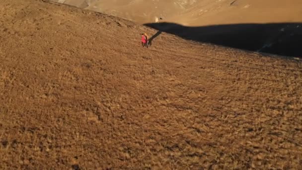 Vue aérienne de deux voyageuses avec des sacs à dos et des caméras monter la colline entre les rochers épiques dans les montagnes. Les filles photographes avec leurs appareils photo au coucher du soleil .