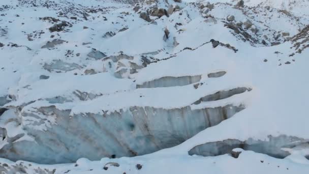 空中视野近距离的流动冰川覆盖着雪和石头高在山上。冰川融化和全球变暖的自然破坏 — 图库视频影像