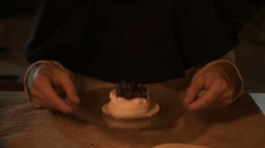Mum ışığında karanlık bir odada bir memnun kız sihirbaz Close-up kendini bir pasta conjured. Pasta düşük anahtar canlı kamera bir tabak tutar. Mistik. Küçük Dof