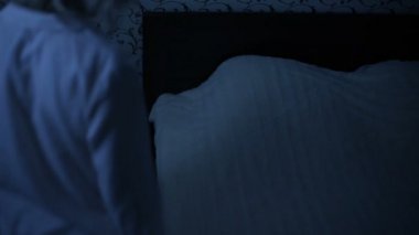 Orta çekim kız gece pijama yatağa gelip yatağa gidiyor. Uyku için hazırlık. Amerikan gece etkisi. Düşük anahtar soğuk ışık İmitasyon gece
