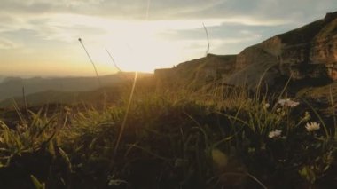 Günbatımı gökyüzü bulutlu bir kayalık vadide içinde düşük bir anahtar. Gün batımında rock massif dibinde arazi Panoraması. 4 k ılık ışık