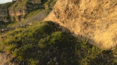 Günbatımı gökyüzü bulutlu bir kayalık vadide içinde düşük bir anahtar. Gün batımında rock massif dibinde arazi Panoraması. 4 k ılık ışık