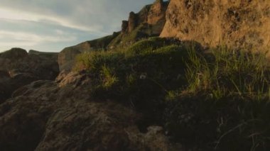 Günbatımı gökyüzü bulutlu bir kayalık vadide içinde düşük bir anahtar. Gün batımında rock massif dibinde arazi Panoraması. 4 k ılık ışık