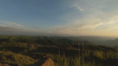 Günbatımı gökyüzü bulutlu bir kayalık vadide içinde düşük bir anahtar. Gün batımında rock massif dibinde arazi Panoraması. 4 k ılık ışık