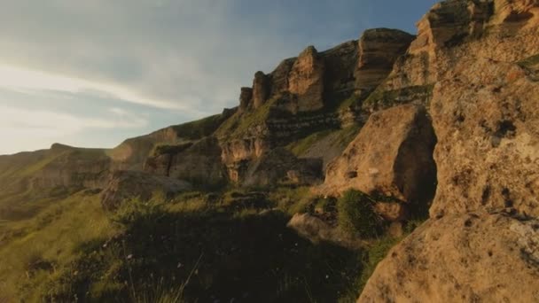 Céu do por do sol com nuvens em um vale rochoso em uma chave baixa. Panorama do terreno ao pé do maciço rochoso ao pôr do sol. Luz quente 4k — Vídeo de Stock