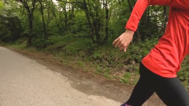 Ragazza in corsa. Ragazza bionda che fa sport all'aria aperta nella foresta estiva. Vista laterale grandangolo rallentatore — Video Stock