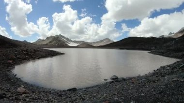 Timelapse gorge kayalıklarla ve gökyüzü gölge ve bulutlar hareketli dağ gölü. Kuzey Kafkasya. Rusya