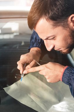 Bir profesyonel ön cam tamirci Close-up özel bir polimer ile cam bir boşlukta bir şırınga ile doldurur. Çatlak ve windshields üzerindeki fişlere ortadan kaldırılması