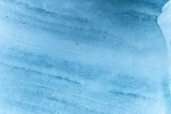 Parete ravvicinata di un ghiacciaio secolare con una struttura a strisce e bolle. Ghiaccio azzurro texture leggera — Foto Stock