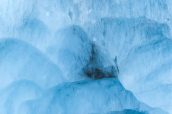 一个有着数百年历史的冰川的近距离模糊的墙壁, 有条纹和气泡的结构。冰蓝色光纹理 — 图库照片