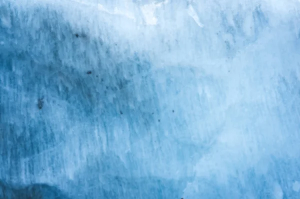 一个有着数百年历史的冰川的近距离模糊的墙壁, 有条纹和气泡的结构。冰蓝色光纹理 — 图库照片
