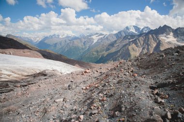 Dağ manzara tozlu kirli volkanik yamaç ile kırık bir erime buzul Kafkas Dağları zemin karşı. Küresel ısınma. Kuzey Kafkasya buzulların
