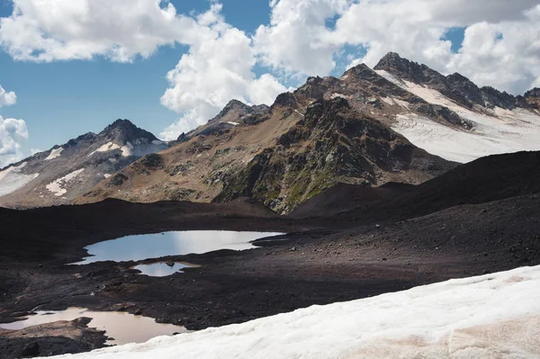 Wysoka góra krajobraz jeziora wulkaniczne góry na zboczu snu wulkan Elbrus z wysokich gór i ośnieżone góry w lecie — Zdjęcie stockowe