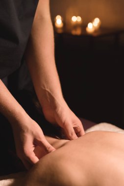 Mens el masaj bir masaj koltuğu masaj Spa karanlık aydınlatma ile yatan bir kız için bir tedavi boyun yapacaklar. Yakın çekim. Karanlık anahtar