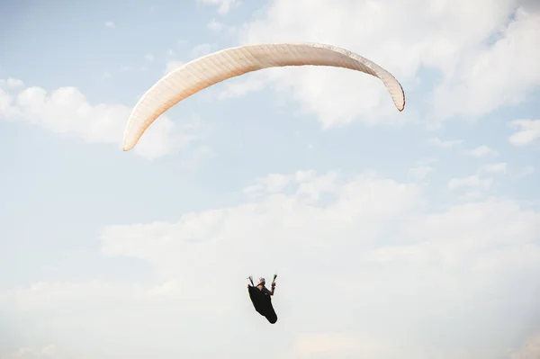 Parapente profesional en un traje de capullo vuela por encima del suelo contra el cielo — Foto de Stock