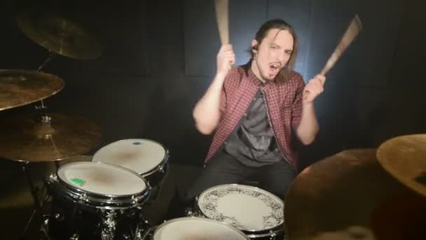 Long-haired drummers play drum kit in a dark room on a black background. Rock musician. Static plan. Wide angle — Stock Video