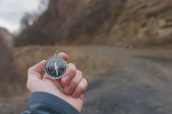 男性ハイカーは、秋に山で磁気コンパスで方向を探しています。ビューのポイントを撮影しました。手マン時計ブレスレットを保持するコンパス — ストック写真