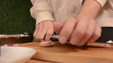 Eller ev mutfak ahşap kesme tahtası üzerinde bir kızın Close-up onları temizlemek için dürüst diş dövüyor. Ev yemekleri