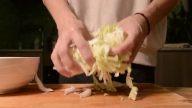 Ev mutfak ahşap kesme tahtası bıçak Pikinsky lahana salatası için üzerinde bir kıza el Close-up. Ev yemekleri