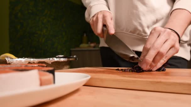 Detailní záběr rukou dívka v domácí kuchyni na dřevěné krájecí desky malé cherry rajčátka. Domácí vaření — Stock video