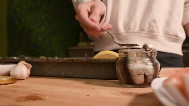 Close-up of hands of a girl at the home kitchen lays out sprats from a glass jar on a tray with a dish. Healthy home cooking — Stock Footage Close-up of hands of a girl at the home kitchen lays out sprats from a glass jar on a tray with a dish. Healthy home cooking Royalty Free Stock Video