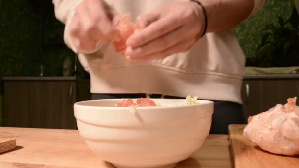 Close-up van handen een meisje op de binnenlandse keuken reinigt en hakt grapefruit voor een vegetarische salade. Gezond thuis koken — Stockvideo