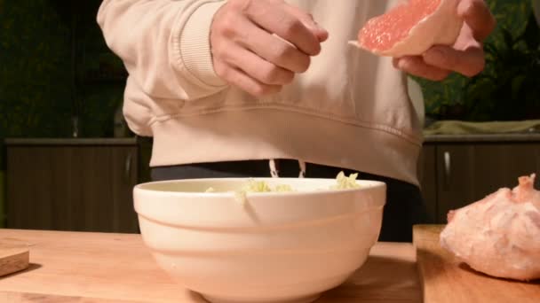 Close-up de mãos uma menina na cozinha casa limpa e costeletas toranja para uma salada vegetariana. Cozinha caseira saudável — Vídeo de Stock