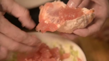 Eller bir ev mutfak at kız closeup temizler ve bir vejetaryen salata için greyfurt pirzola. Sağlıklı ev yemekleri