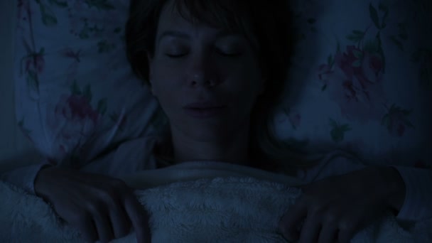 Nahaufnahme eines nächtlichen Mädchens, das im Bett liegt und beim Anblick der Decke nicht schlafen kann. Blick von oben — Stockvideo