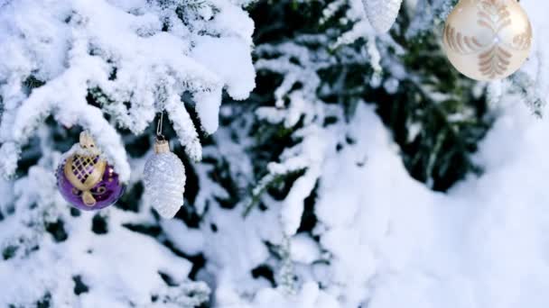 Gros plan d'un jouet de Noël sur un arbre animé enneigé dans la forêt d'hiver sur fond de lumières
