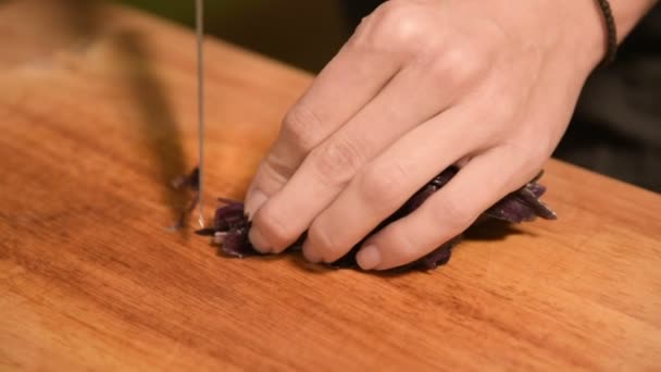 Nahaufnahme der Hände eines Mädchens in der heimischen Küche auf einem hölzernen Schneidebrett kleine Kirschtomaten. Hausmannskost — Stockvideo