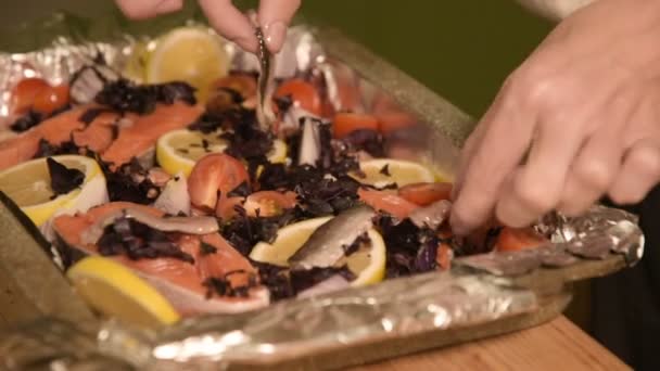 Close-up van handen van een meisje op de binnenlandse keuken legt sprot uit een glazen pot op een dienblad met een schotel. Gezond thuis koken — Stockvideo