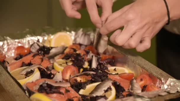 Close-up van handen van een meisje op de binnenlandse keuken legt sprot uit een glazen pot op een dienblad met een schotel. Gezond thuis koken — Stockvideo