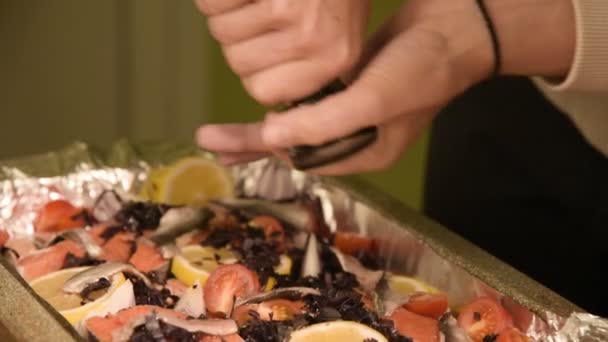 Close-up of hands of a girl at the home kitchen is salting or peppering a dish in a prodvin of a manual mill. Healthy home cooking — Stock Video