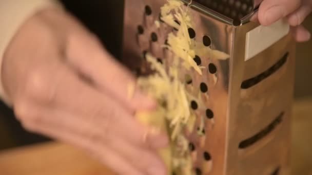 Närbild kvinnans hand gnuggar rengöras ingefära på en metall rivjärn. Hälsosam naturlig mat — Stockvideo
