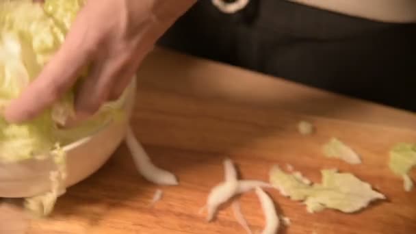 Närbild på händerna på en flicka på hemmet köket på en trä cutting board knivar Pikinsky kål för sallad. Husmanskost — Stockvideo