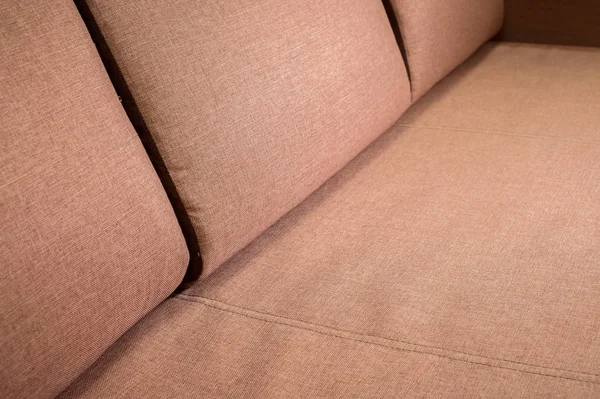 A close-up of a fragment of an expensive beige textile sofa in the room — Stock Photo, Image