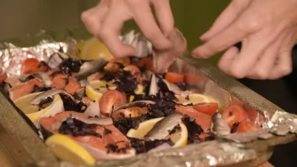 Close-up of hands of a girl at the home kitchen lays out sprats from a glass jar on a tray with a dish. Healthy home cooking — Stock Video