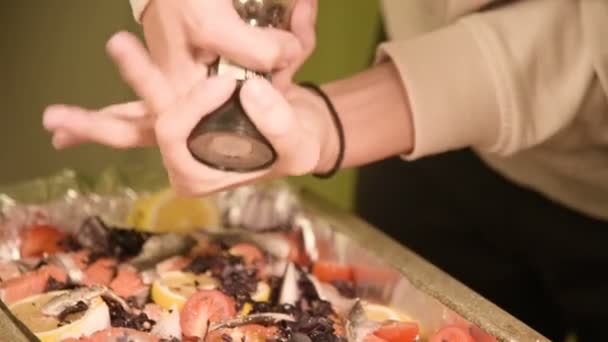 Close-up van handen van een meisje op de binnenlandse keuken is zouten of een gerecht in een prodvin van een handmatige molen peppering. Gezond thuis koken — Stockvideo