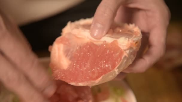 Close-up de mãos uma menina na cozinha casa limpa e costeletas toranja para uma salada vegetariana. Cozinha caseira saudável — Vídeo de Stock