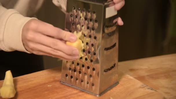 Close-up womans frota la mano limpió la raíz de jengibre en un rallador de metal. Alimento natural saludable — Vídeo de stock