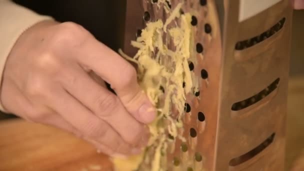 Close-up mulheres mão esfrega raiz de gengibre limpo em um ralador de metal. Alimentos naturais saudáveis — Vídeo de Stock