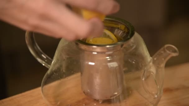 Gros plan des mains féminines coupent un couteau avec des citrons en morceaux et pressent pour faire du thé sur une table en bois de cuisine maison. Thé maison — Video