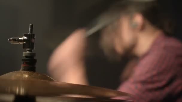 Bateristas de cabelos compridos tocam bateria em uma sala escura em um fundo preto. Músico de rock. Plano estático. Ângulo largo — Vídeo de Stock